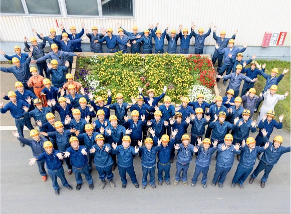 社屋の前でバンザイする大勢の従業員を俯瞰で見た画像